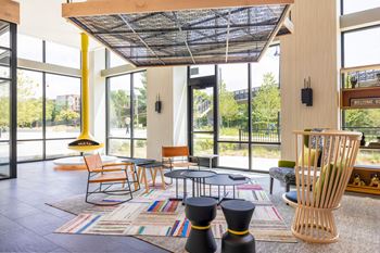a living room with tables and chairs and large windows at The Chase at Bryant Street, Washington, DC